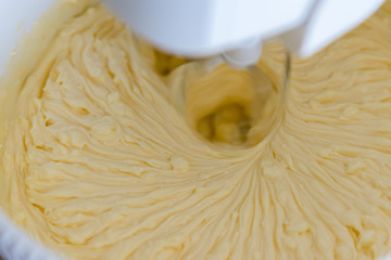 close up of twist white cream spiining in the blow. White mixer whip the dough