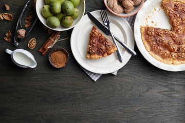 Traditional walnut pie with spices and nuts on dark wooden table, top view
