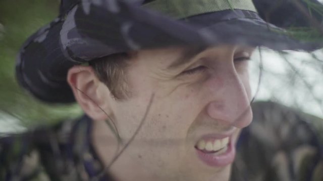 Young male explorer lost in tropical jungle scans his surroundings