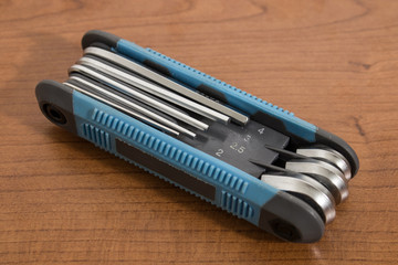 Blue multitool allen keys on a wood table