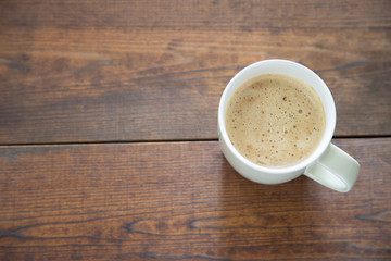 A cup of coffee on wooden background