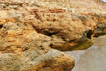 beautiful sea landscape, closeup of stone on the beach, sea coast with high hills, wild nature