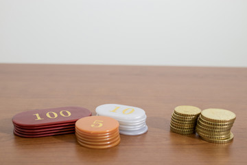 Euro coins and casino chips on a wood table