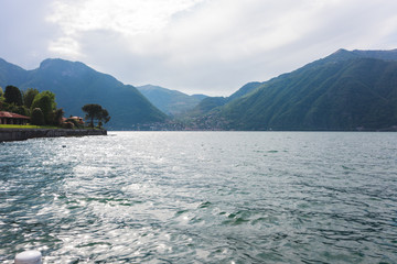 Blick auf Comer See im Sonnenlicht Glanz auf Wasser und Berg Landschaft im Hintergrund