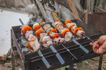 the man sets the meat on the skewer, prepares on the grill delicious barbecue