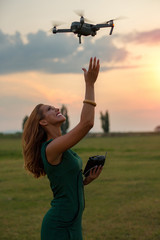 Young woman landing a drone in her hand
