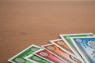 Colored fake banknotes on a wood table