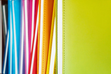 Books with colorful covers. Pile of books in one row on book shelf with selective focus. Bright color texture for background      