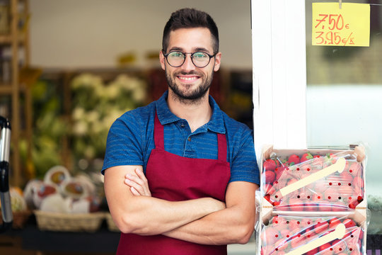 Portrait Of Handsome Young Salesman Looking At Camera In Health Grocery Shop.