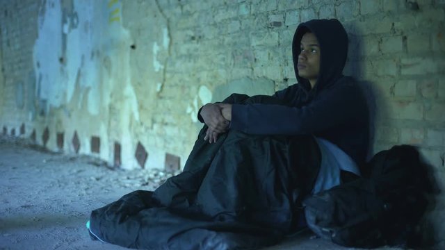 Homeless teenager watching people passing by indifferently, abandoned by society