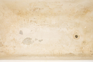 Old cracked cast iron tub.Damaged bath cover.