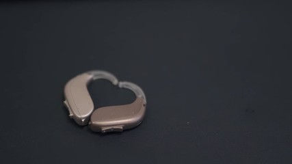 Two hearing aids on the table are lined in the form of a heart