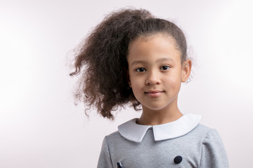 Portrait of cute little beautiful mulato girl with luxury ponytail. isolated white background....