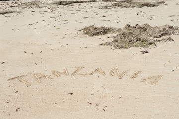 Inscription Zanzibar, Tanzania on the light sand on the beach at low tide