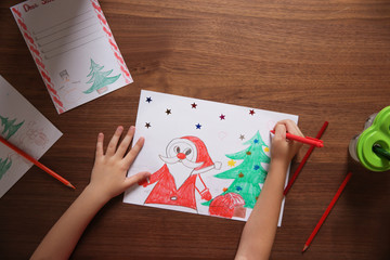 Naklejka premium Little child drawing picture at table, top view. Christmas celebration
