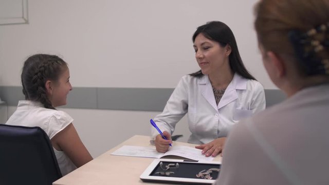 Mom and daughter communicate with a young doctor