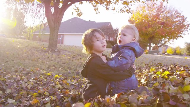 5 year old boy tries to comfort grumpy toddler, who pushes him away