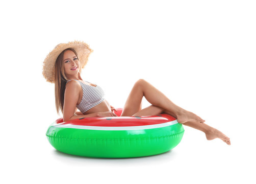 Sexy young woman in bikini with inflatable ring on white background
