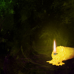 Yellow candle on black background.