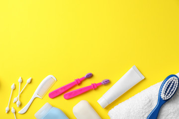Flat lay composition with baby toothbrushes, toiletries and space for text on color background