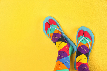 Woman wearing bright socks with flip-flops and space for design on color background