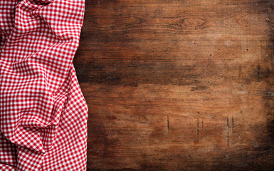 Red white checkered picnic tablecloth on wooden background, copy space - Powered by Adobe