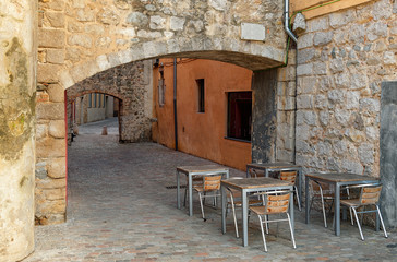 Fototapeta na wymiar Empty outdoor cafe in the medieval street in Girona Spain