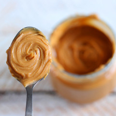 peanut butter in a spoon on a light background