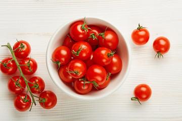 Fresh Red Cherry tomatoes in bowl on wooden background. Ingredients for cooking. 