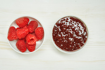 Raspberries jam with fresh red ripe on wooden background. Top view.