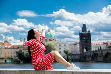 Beautiful girl in red dress travel in Prague, city streets