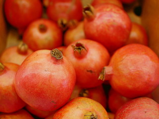 Fototapeta na wymiar Close up and selective focus background of bright organic red pomegranates