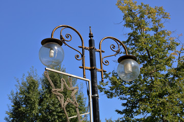 Vintage iron lantern on a city street on a sunny day
