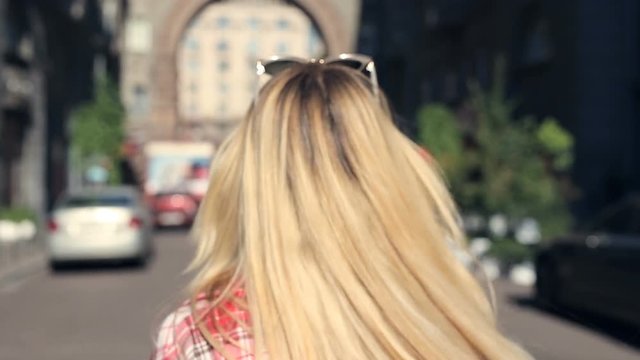 Young blonde woman doing air kiss and good bye gestures, going away.