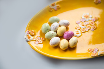 Colorful chocolate Eater eggs on a yellow plate