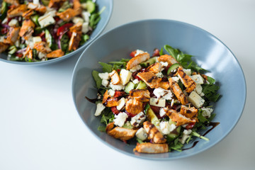 A healthy chicken salad in a grey bowl.