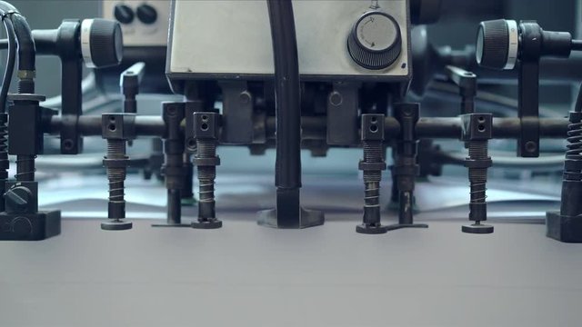 Industrial printer work process. It is printing colorful leaflets. Concept of mass media and typography. Machine at work. Handheld real time close up shot