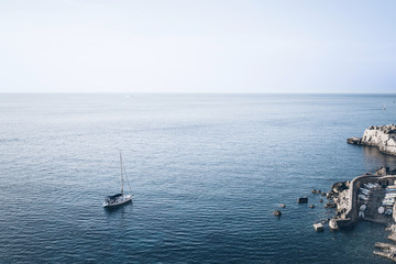 high angle view of small harbor and sailboat against blue sea and sky