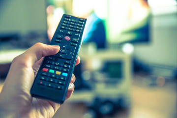 Fernbedienung vor Fernseher in Männerhand 