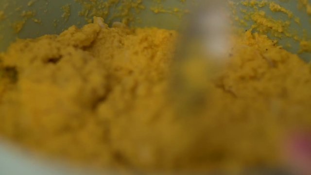 Spoon stirring yellow batter of african food Abar&aacute;