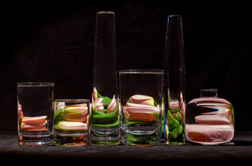 tulips behind water filled glasses