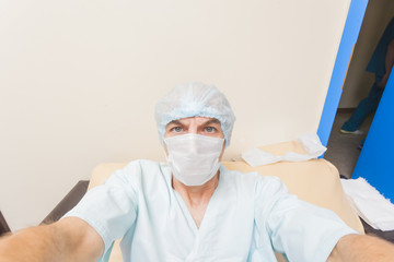 Fototapeta na wymiar doctor or patient in mask makes selfi in a hospital bed
