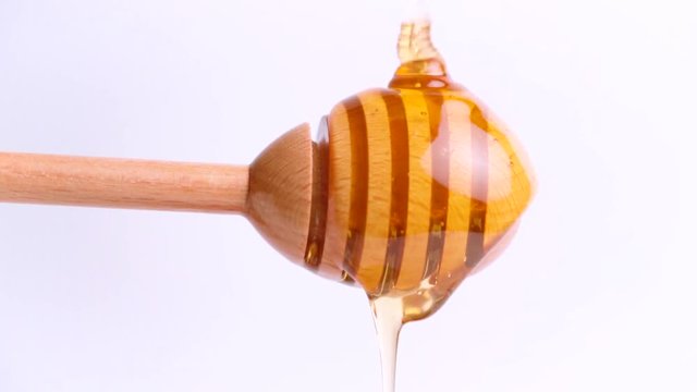 Pouring honey on honey dipper
