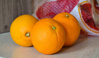 Three oranges on a stone table closeup