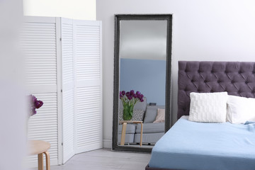 Elegant bedroom interior with large mirror