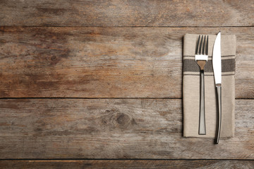 Cutlery and napkin on wooden background, top view. Table setting - obrazy, fototapety, plakaty