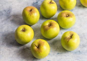 Small green apples on marble surface with selective focus