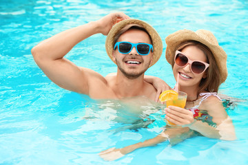 Young couple in pool on sunny day