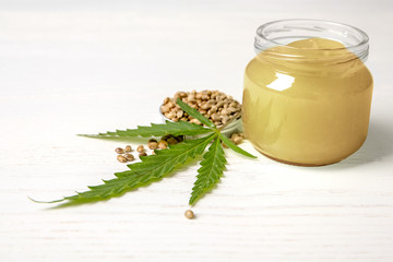 Composition with hemp lotion on white wooden background