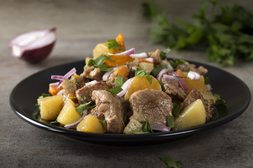 Baked potatoes, pork meat and carrots with herbs